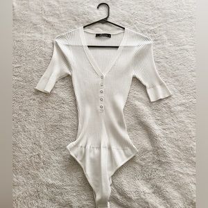 Never work before white 3/4 ribbed long sleeve body suit in white.